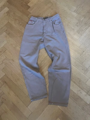 Jackeroo "American Style" Jeans  - vintagejeans från märket Jackeroo i en snygg ljusgrå/beige färg. Robust och kraftigt vintagedenim ("100% pure basic denim") med den klassiska stora läderlappen på baksidan. Perfekt för en skön workwear- eller arkiv-look!