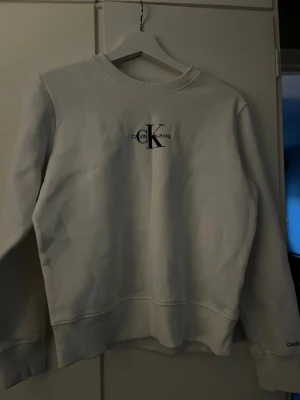 Vit sweatshirt från Calvin Klein Jeans - Vit sweatshirt från Calvin Klein Jeans med logga på bröstet. Storlek S.