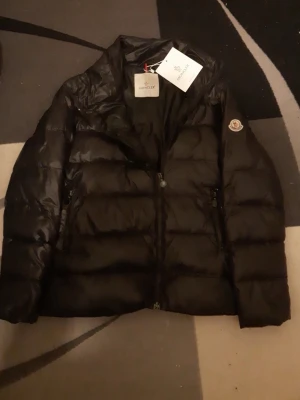 Svart dunjacka från Moncler - Snygg svart dunjacka från Moncler med klassisk quiltad design. Det finns hål i både fickorna. Priset kan diskuteras✅.