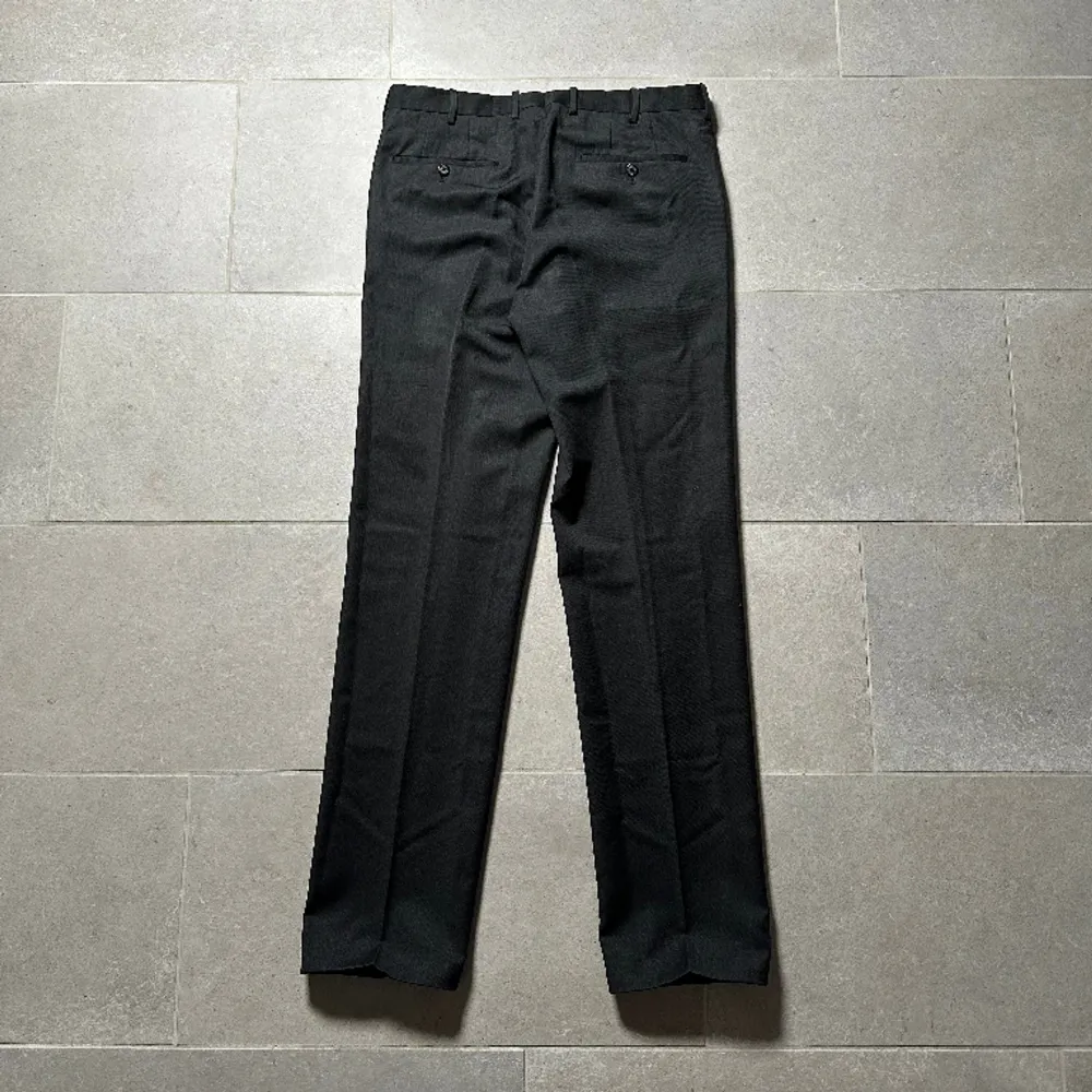 Svarta kostymbyxor från 2007 Prada mainline. Byxorna har en classy lös/rak passform. Innertyget har bytts ut på insidan av en av byxbenen men det är inget som syns från utsidan.. Jeans & Byxor.