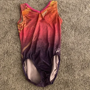Gymnastikdräkt  - Jättefin, lite av glittret är borttvättat men annars är det i bra skick. Storlek AS (passar ca xxs-s). Väldigt strechigt tyg. Har ni några frågar är det bara att höra av er! 