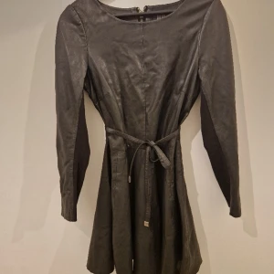 Stilren klänning  - Stilren klänning i skinn från märket Jofama. Smickrande modell i storlek 38. Använd endast enstak gånger.