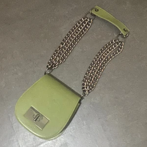 Axel väska från NA-KD - Nästan aldrig använd axelväska från NA-KD finns inte längre på hemsidan. Finns 4 olika fack 3 inuti väska n var av en är med dragkedja och dem andra är öppna senan finns det även en liten ficka på baksidan av väskan. Är i riktigt bra skick.