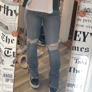 Jeans med hål i knäna - Gråa Zara jeans med hål i knäna! Slits vid fötterna o klippa så de är i bra längd till mig som är 162💞 säljs pågrund av att jag använder andra jeans mer!