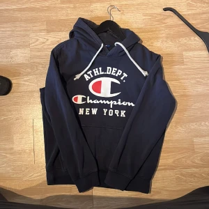 Champion hoodie  - Säljer en mörkblå Champions hoodie pga brist på användning. Skick 6/10 men mycket kvar att ge. Nypris 599:- Mitt pris 99:-