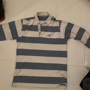 Burrbery långärmad piké  - Tja, säljer nu denna feta burrbery pikén som är i topp skick och inga defekter eller fläckar alls. Den är väldigt schtek och schysst. Säljer den för ett väldigt bra pris. Jag svarar snabbt på frågor som ställs så de är bara att fråga på. Mvh Oscar😃😃✌️