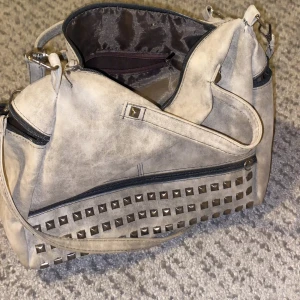 Väska - Stor och ryms med byxor, nitar på en av sidorna