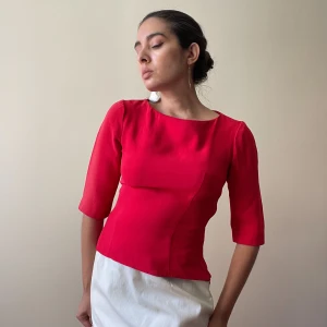 Handmade Red Silk Blouse - Beautiful Red Silk Blouse. Handmade from scrap silk fabric. Darting Details & Boat Neckline for Feminine Silhouette. 3/4 Sleeve & Side Zip 50 CM/ 19.7 IN Length 35 CM/ 13.8 IN Sleeve  37 CM/ 14.6 IN Shoulders 78 CM/ 30.7 IN Chest 68 CM/ 26.8 IN Waist