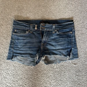 Jeansshorts från Crocker - Ett par blå jeansshorts från Crocker med fransiga kanter och dubbla knappar i midjan💞 Shortsen har fem fickor totalt och orange sömmar på bakfickorna. Dom är låga i midjan och är i bra skick❤️Skriv vid frågor eller fler bilder ❤️