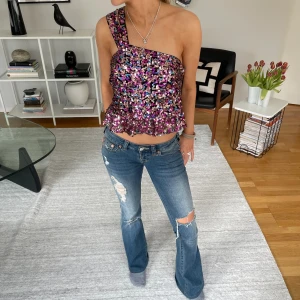 Glittrig top - Så sjukt snygg one shoulder top. Köpt second hand men i nästintill nyskick. Storlek L men vi uppskattar storleken till en XS-M beroende på hur man vill att den ska sitta. Hör av er privat om ni har några frågor💕