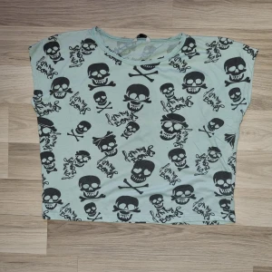 Topp  - Ljusblå topp med döskallar på från Cubus i stl 164. 