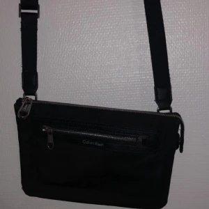 Calvin Klein väska  - Axelremsväska från Calvin Klein. 3 fack som man ser på en av bilderna. Säljs billigt köp för 899 på zalando. 