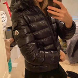 Moncler bady down jacket - Såå snygg moncler dun jacka, nypris runt 9300kr, använd 1 vinter. Väldigt bra skick! Några få defekter som att den tappat lite färg på dragkedja osv storlek 14y men passar mig som vanligtvis bär S💕(Serietidiningen inuti sitter lite löst)