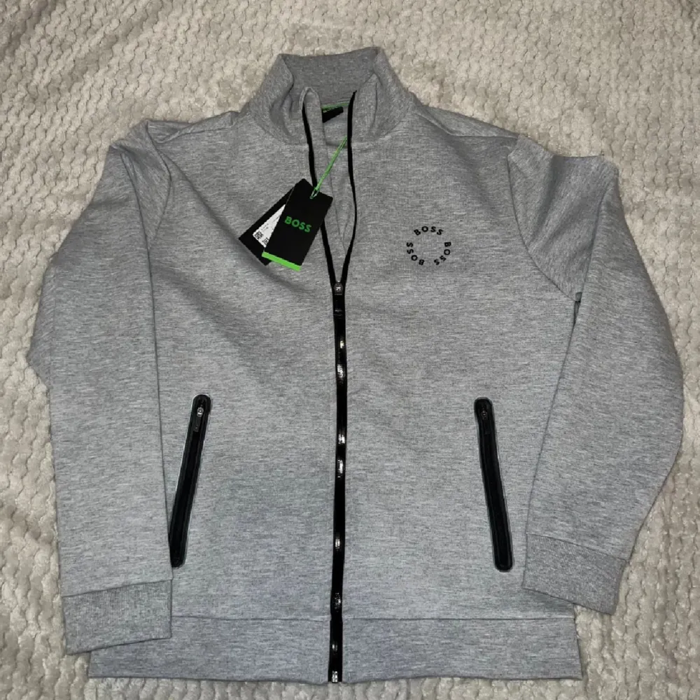 Säljer en helt ny Hugo Boss - Skaz Full-Zip Light Grey. Nypris är 1999 kr. Storlek L.. Tröjor & Koftor.