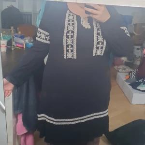 Långärmad tunika/klänning - Svart tunika/klänning i tunt tyg med vita detaljer och snöring på framsida