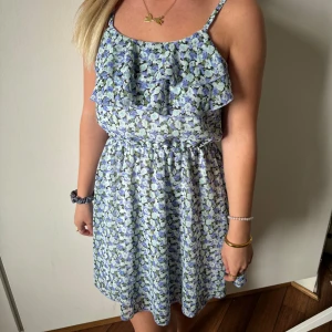 Volangklänning - Volangklänning med blå blommor i bra skick. Storlek 146 men passar XS.