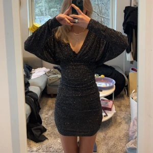 Nyårsklänning - SÅLD❗️❗️ Svart glittrig klänning med djup och pösig uringning, PERFEKT till nyår🤩🥳 