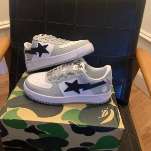 Bape skor  - Säljer ett par Bape skor i stl 43, helt oanvända så 10/10 i skick. Fråga efter flera bilder om det är nått annat ni vill se.  Extra snören och påse följer med. Priset kan diskuteras vid snabb affär .