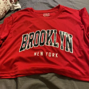 Brooklyn T-Shirt kroppad - En fin Kroppad T-Shirt med motivet BROOKLYN NEW YORK. Tröjan är mörkröd och har lite tajtare passform.