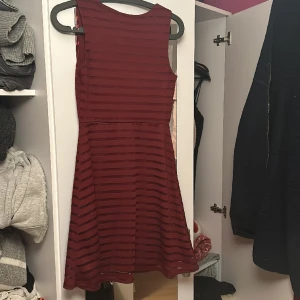 Röd Julklänning - Fin julklänning använd en gång. Den är i nyckick och passar storlek XS. Från bodyflirt. Med ett fint randigt mönster. Pris 250, nypris 599