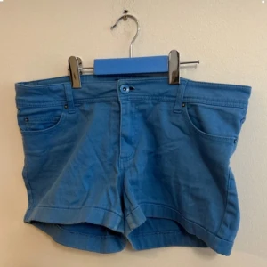 Blåa shorts från red lebel i mycket bra skick - Kortare shorts med låg midja i storlek L. I mycket bra skick. Inget att anmärka på.   Mått  Midjebredd 38cm Längd från midja 26cm