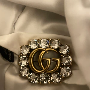 Gucci brosch  - Gucci brosch. Köpt i Italien. Aldrig använd, kommer med dustbag och kartong.