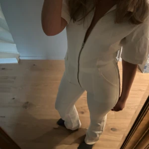 Jeans byxdress  - Så himla fin vit byxdress i jeans från mango. Aldrig andvänd. Helt perfekt till sommaren eller kanske till vilda vesten tema. Inte genomskinlig vad jag märkt. De har en bootcut modell nertill. Storlek 38.  