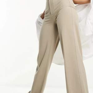 Snygga sköna beiga / svampfärgade (enligt beskrivningen på hemsidan) kostymbyxor med vidare ben och tighta vid rumpan.