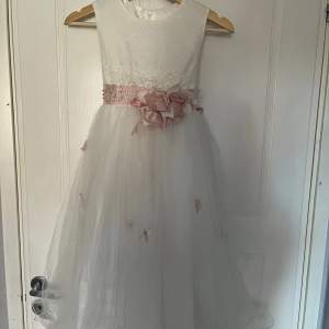 Bra skick, vit klänning med rosa fjärilar, rosetter, pärlor, diamanter. Storlek 8 till 11 år. 