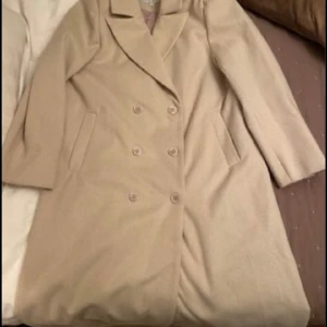 Kappa - Supercool lång kappa i storlek 42. Beige/vit med snygga detaljer. Använd en gång. Ev. frakt betalas av köpare. 