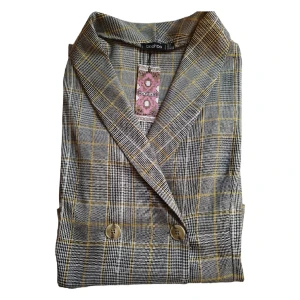 Rutig ljusgrå Blazer klänning i nyskick.   - Rutig ljusgrå Blazer klänning i nyskick.  Prislapp kvar  OBS: Första bilden är tagen av mig(klänningen är ljusare i verkligheten).  Resterande två är lånade av BOOHOOs hemsida.