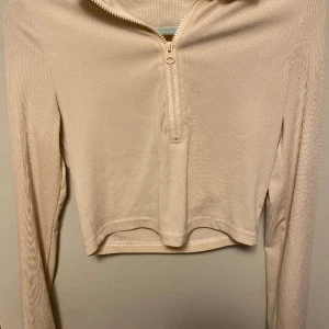 Beige tröja - Beige långärmad tröja. Fin och stilren, ganska tunn, dragkedja, ljus och bekväm, kanska kort till naveln ungefär