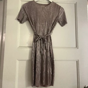 Klänning  - Superfin ljusrosa glitterklänning som passar perfekt till nyår! Går att bära med eller utan band i midjan.