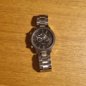 Silver klocka - One size, den är i bra kondition, fungerar perfect, 24 cm rem, enkel att ta på och ta av, kontakta mig om ni har frågor. 