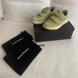 Acne studios sneakers - Acne Studios ”Velcro strap sneakers” i storlek 38. Sparsamt använda, och inga defekter förutom att de är lite smutsiga runt sulan, men går att putsa upp! Mocka/ suede material. Skickas i medhörande orginalförpackning och dustbags! Nypris: 4300 SEK