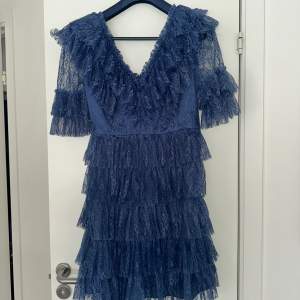 En blå klänning i storlek S från By Malina. Använd vid endast ett tillfälle och har inga defekter. Nypris 2800 säljer nu för endast 1100 kr + frakt kostnaden. Klänningen är i spets och har vollanger.