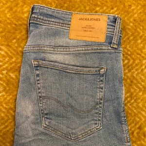 Jack & Jones Liam Jeans - Ljusblå jeans i skiny modell. Stretchigt tyg. Storlek W32 L32. Inget synbart slitage.