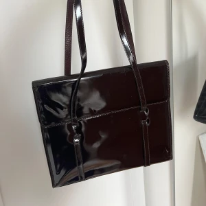 Mörkbrun större väska  - En glansig lite större väska, skulle kanske kunna användas som lättare skolväska! Obs! Kan förekomma några små repor (se bild 3 för exempel)❤️