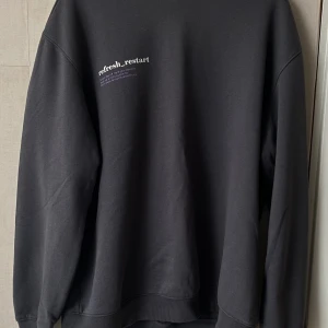 Tröja, blomma baksida - Denna tröja är en storlek small fast är designed att va lite ”oversize” den ör fotfarande lös om man har medium som storlek. Den är gjord utav bomull och inte använts många gånger.