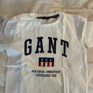 Gant t-shirt - Jag säljer min vita gant t-shirt som är i bra skick, förutom ”reporna” på texten (man ser de på bilden). 