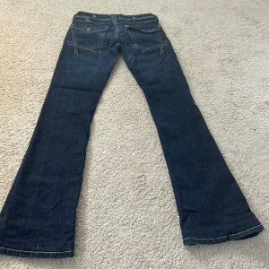 Mörkblå lågmidjade bootcutjeans med coola fickor - Så fina!