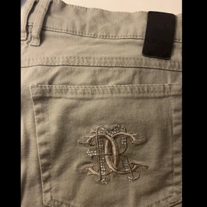 Robell Jeans - Olivgröna/grå Robell regular jeans modell Chris i storlek 40. Fin detalj på högra bakfickan. Bra skick men lite nopprigt mellan benen (se 3:e bilden). Pris kan diskuteras🤍