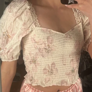 Ljusrosa blommig blus - Gullig, blommig blus som aldrig kommit till användning och har prislappen kvar. Den har smock, puffiga ärmar och knytdetalj❤️ Kom gärna med frågor eller prisförslag! (Säljer även på Vinted)