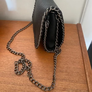 Svart axelväska med kedja - Säljer denna väska då jag pga att jag aldrig har kunnat använda den 🫶🤗☺️💞kan gärna gå ner i pris 