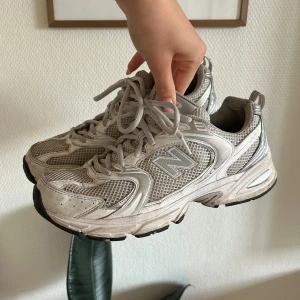 Gråa sneakers från New Balance - Vita sneakers från New Balance. De är i välanvänt skick men fortfarande bekväma och funktionella. I behov av lite kärlek! Skorna har snörning och är tillverkade i syntetmaterial med meshdetaljer för bra ventilation. Perfekta för vardag eller träning 🤍 Nypris: 1399kr.  mitt pris:  150kr