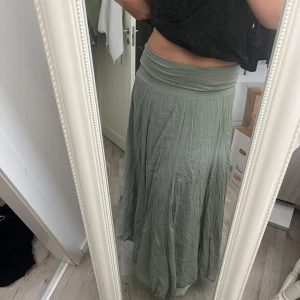 Grön långkjol  - En grön långkjol, köpt på en marknad i Amsterdam. Jag är 175 och den går ner till anklarna. Säljer pga den är lite för kort för min smak. Finns ingen riktig storlek, men passar mig som brukar ha M