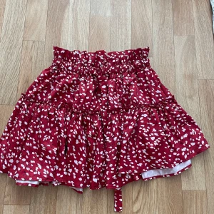 Röd blommig kjol från EIN - En röd blommig kortkjol från SHIEN med elastisk midja och volangdetaljer. Det går bra att bara köpa ett av plaggen och inte som ett sätt om man vill🤗