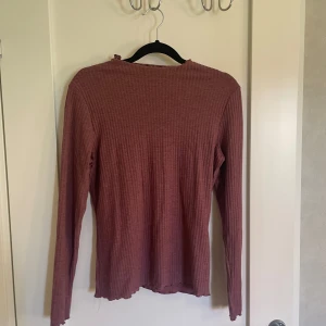Rosa ribbad tröja - Säljer en superfin vinröd ribbad tröja. Den är långärmad och perfekt för höst och vinter. Tröjan är i bra skick endast använd fåtal gånger. Den är mjuk och bekväm att ha på sig. Passar dig som gillar en normal passform.
