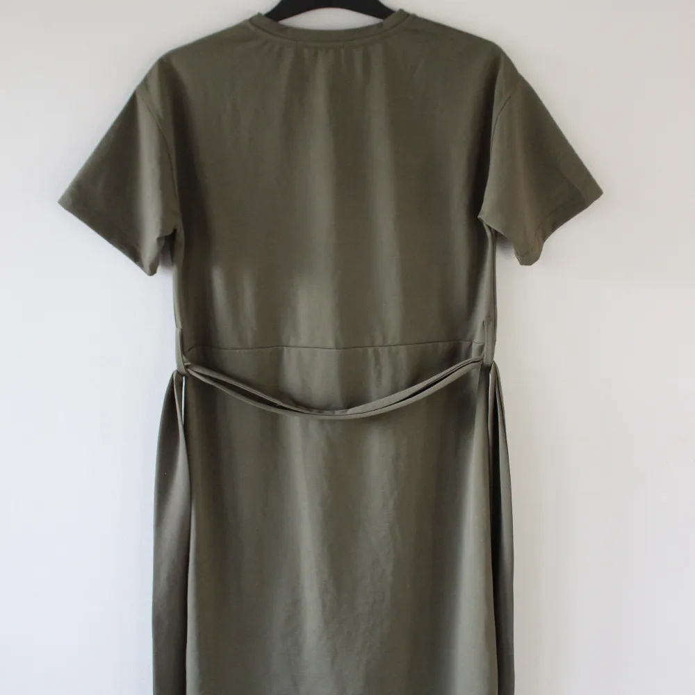 Olivgrön klänning, storlek 8 från Warehouse, har en ficka och midjeband. Har aldrig använts, superbra kvalitet! Den är lite gröna är på de första bilderna, se sista bilderna.. Klänningar.