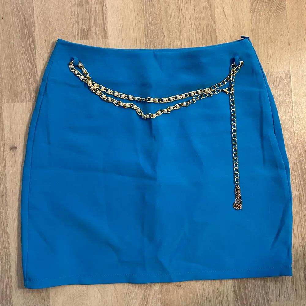 Jättesnygg blå kjol med guldiga detaljer, perfekt till sommaren. Endast använd en gång där med i nyskick, pris går att diskutera vid snabb affär. . Kjolar.